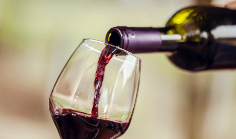 Pouring Red wine into the Glass against blur background